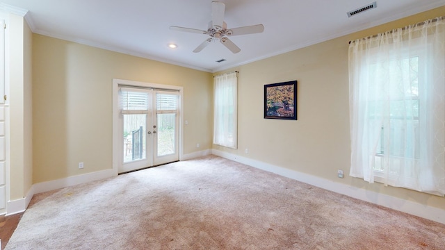 carpeted empty room with crown molding, french doors, and ceiling fan