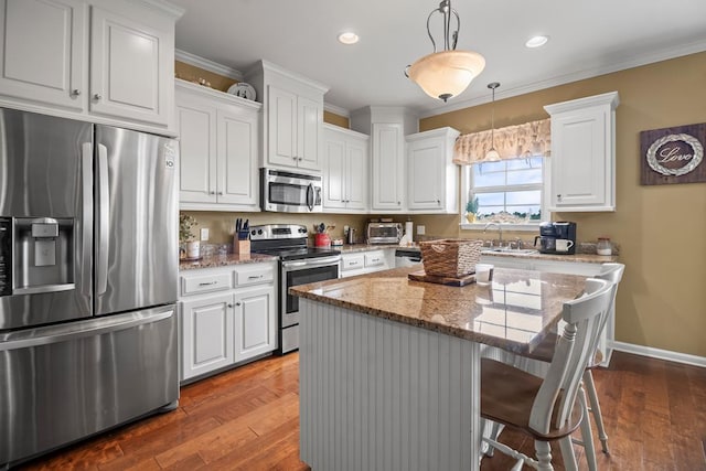 118 Brookstone Ct, Headland, AL 36345 - kitchen featuring dark wood-style flooring, light stone countertops, a center island, white cabinetry, and appliances with stainless steel finishes