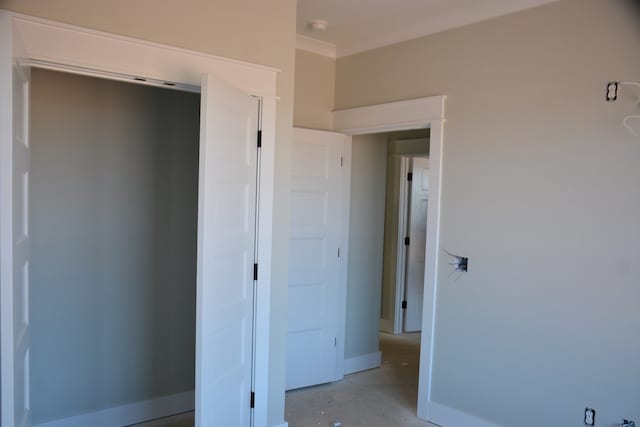 unfurnished bedroom with a closet and ornamental molding