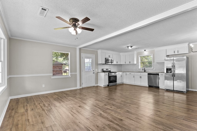 kitchen with white cabinetry, dark hardwood / wood-style flooring, stainless steel appliances, and plenty of natural light