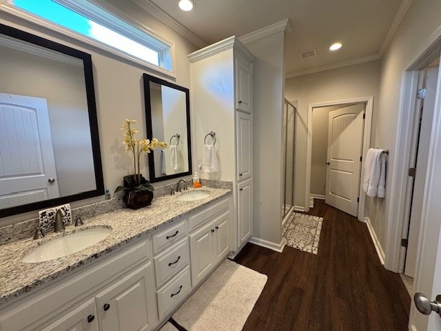 70 Beckett Ln, Newton, AL 36352 - bathroom featuring wood finished floors, a stall shower, crown molding, double vanity, and recessed lighting