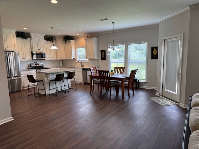 70 Beckett Ln, Newton, AL 36352 - dining area featuring healthy amount of natural light, crown molding, dark wood-type flooring, baseboards, and recessed lighting