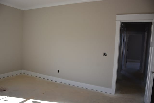 spare room featuring concrete flooring and crown molding