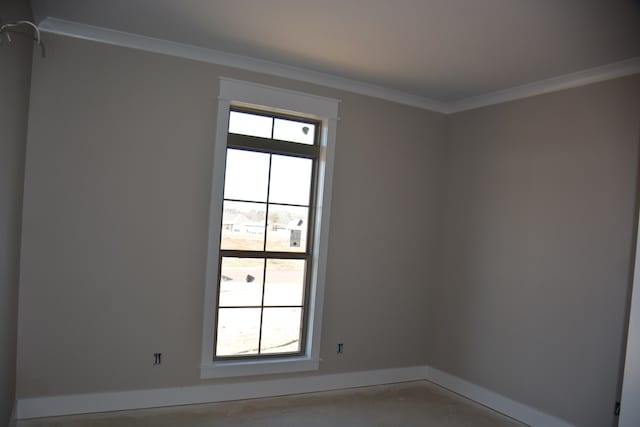 spare room featuring a healthy amount of sunlight, concrete flooring, and crown molding