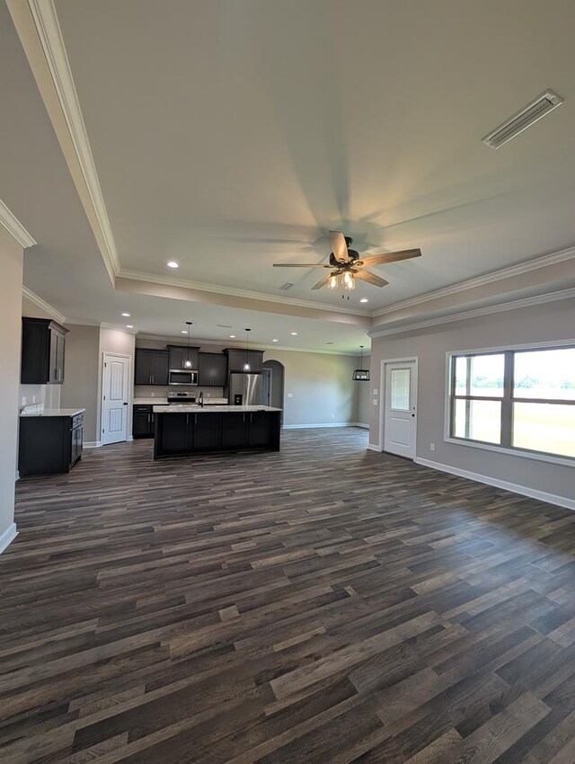 12611 Fortner St, Newton, AL 36352 - unfurnished living room with ceiling fan, baseboards, dark wood-style flooring, crown molding, and a raised ceiling