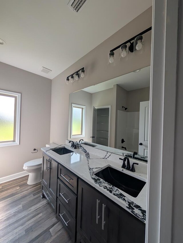 12611 Fortner St, Newton, AL 36352 - bathroom featuring toilet, a shower, double vanity, wood finished floors, and baseboards