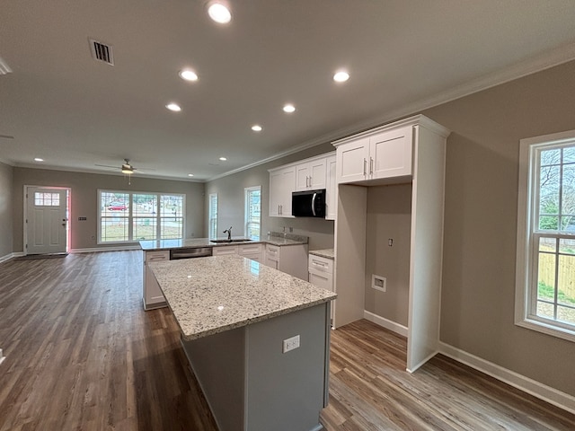 kitchen featuring sink, white cabinetry, a center island, stainless steel dishwasher, and kitchen peninsula