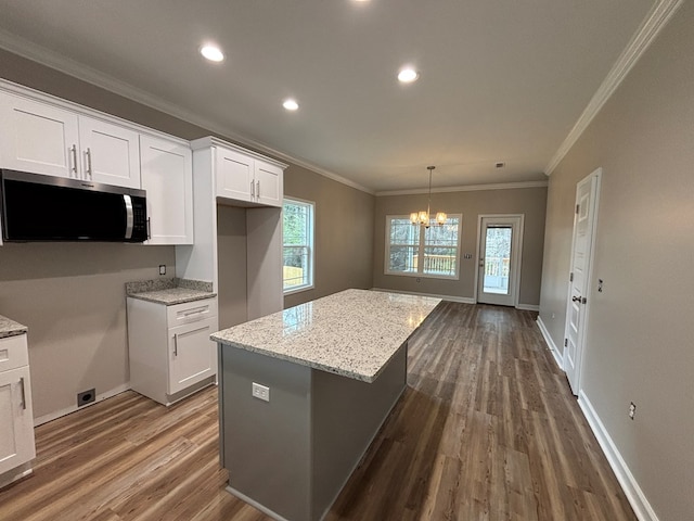 kitchen with white cabinetry, light stone countertops, and a kitchen island