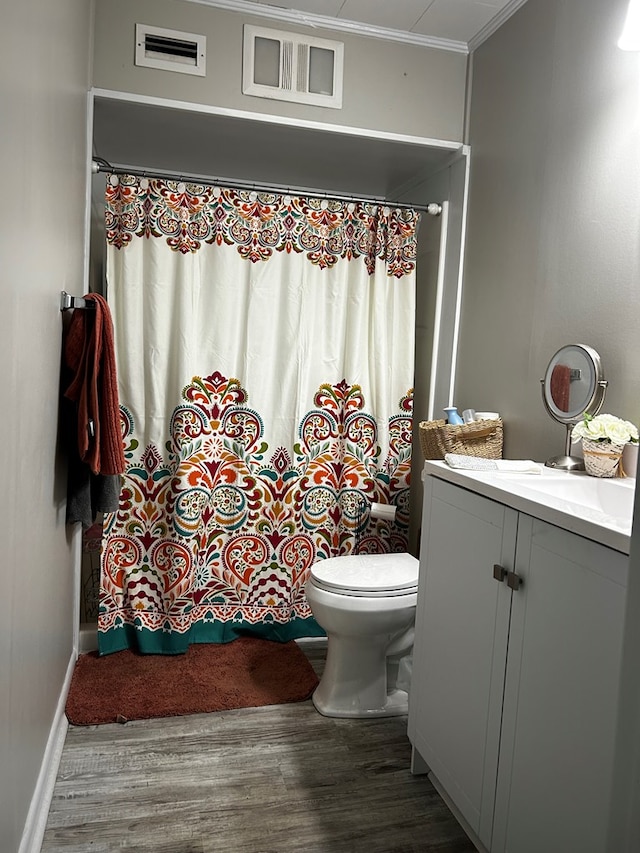 full bath with visible vents, toilet, wood finished floors, crown molding, and vanity