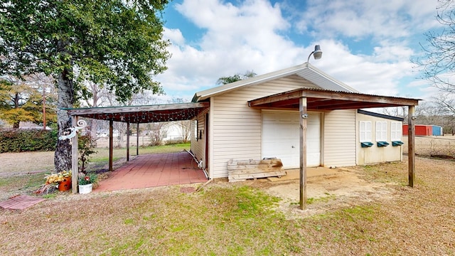 rear view of house featuring a yard, a garage, and a carport