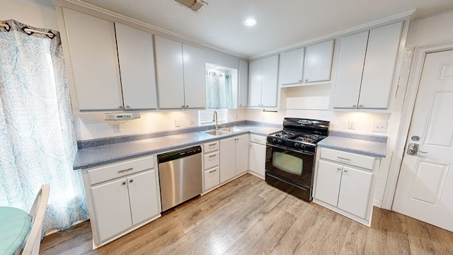 kitchen featuring sink, stainless steel dishwasher, white cabinets, and black gas stove