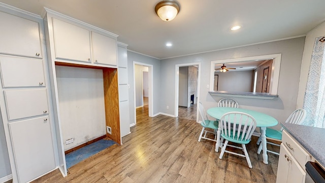 dining space with ornamental molding, ceiling fan, and light hardwood / wood-style flooring