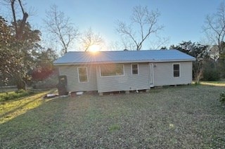 rear view of house featuring a yard