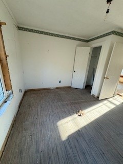 unfurnished bedroom featuring crown molding and carpet flooring