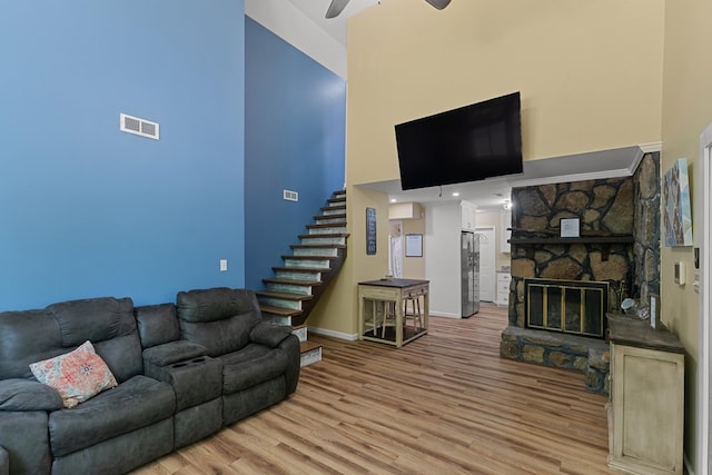 8165 County Road 97, Abbeville, AL 36310 - living room with a towering ceiling, stairway, a ceiling fan, light wood finished floors, and baseboards