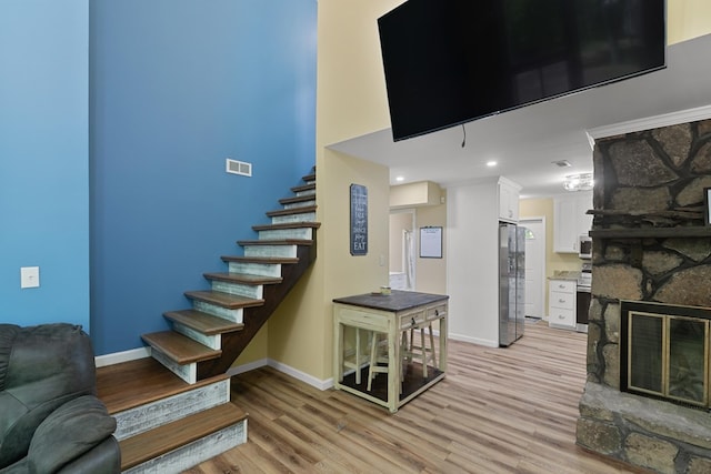 8165 County Road 97, Abbeville, AL 36310 - staircase featuring wood finished floors, a fireplace, and baseboards