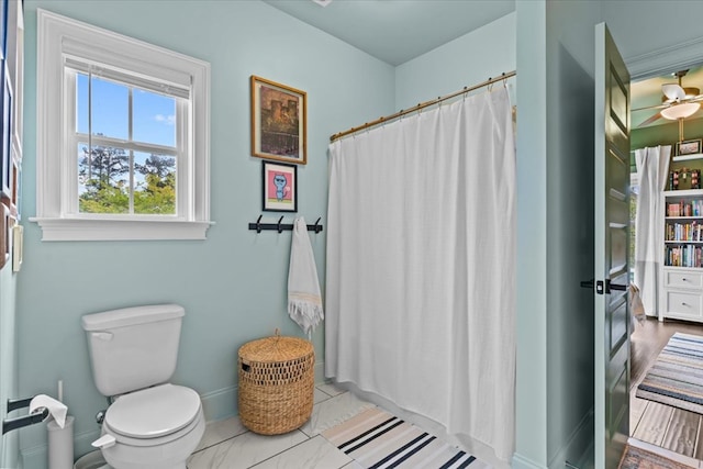 bathroom featuring toilet, a shower with curtain, and baseboards