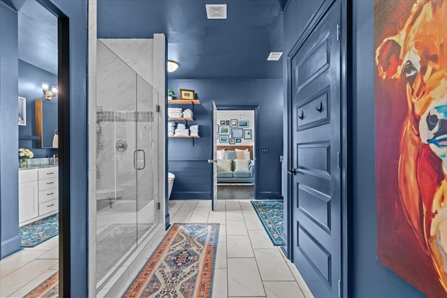 bathroom featuring toilet, visible vents, vanity, and a stall shower