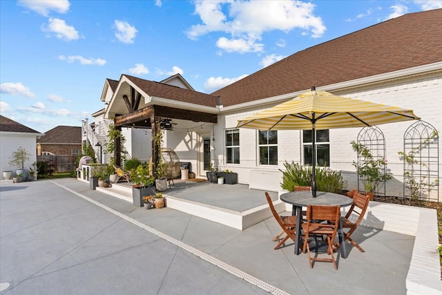 view of patio with fence, outdoor dining space, and a ceiling fan