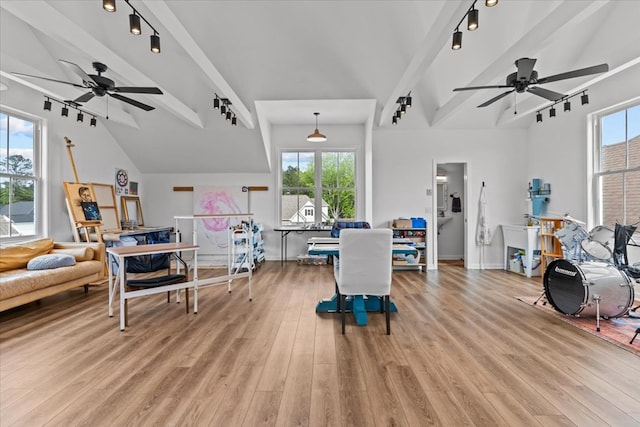 living room featuring track lighting, ceiling fan, lofted ceiling with beams, and light wood-style floors