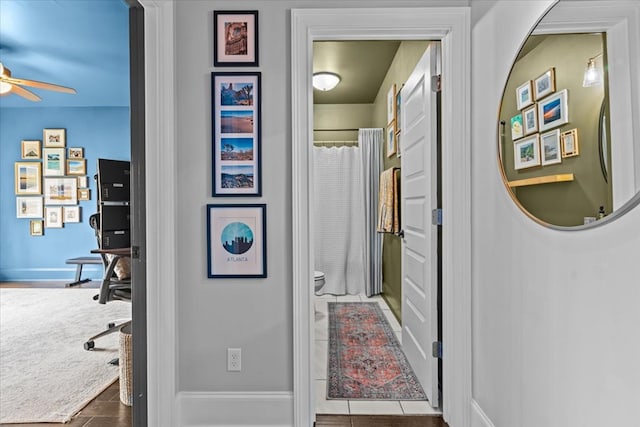 hallway with tile patterned flooring and baseboards