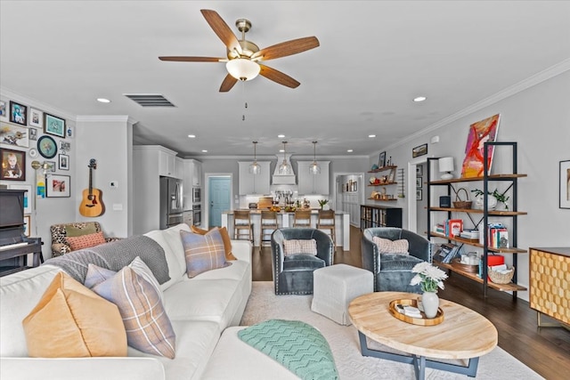 living area featuring dark wood finished floors, recessed lighting, visible vents, a ceiling fan, and crown molding