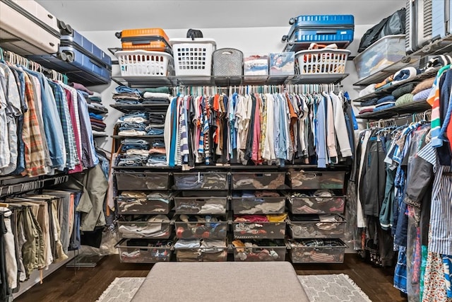 walk in closet with wood finished floors
