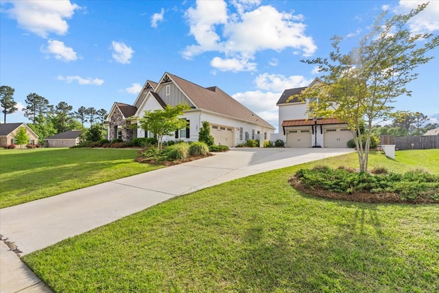 view of front of house with board and batten siding, fence, driveway, a front yard, and an attached garage