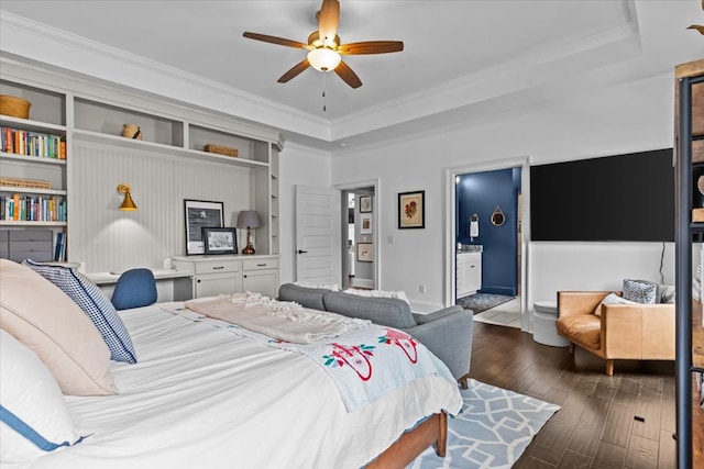 bedroom with hardwood / wood-style flooring, crown molding, ceiling fan, a tray ceiling, and baseboards