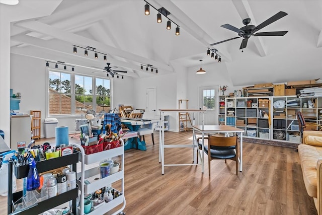 recreation room with beam ceiling, rail lighting, wood finished floors, a ceiling fan, and high vaulted ceiling