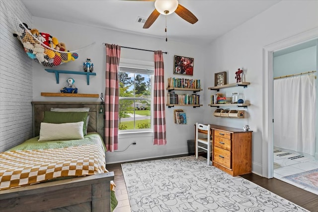 bedroom with baseboards, visible vents, wood finished floors, and a ceiling fan