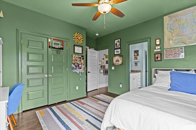 bedroom featuring ceiling fan, ensuite bathroom, baseboards, a closet, and wood finished floors