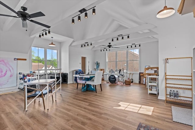 dining area featuring baseboards, track lighting, wood finished floors, a ceiling fan, and high vaulted ceiling