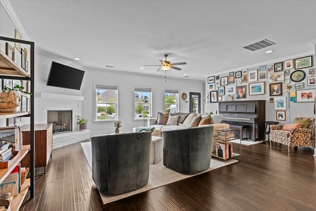 living room featuring recessed lighting, a fireplace, ceiling fan, crown molding, and dark wood finished floors
