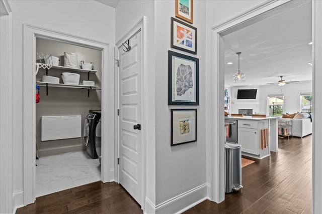 hallway with washing machine and dryer, dark wood-style flooring, and baseboards