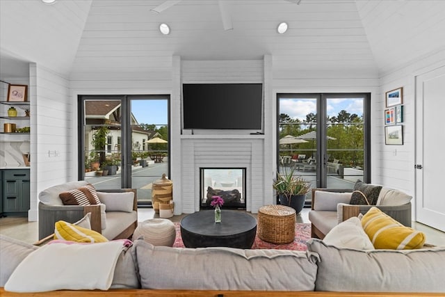 living area featuring a multi sided fireplace and lofted ceiling