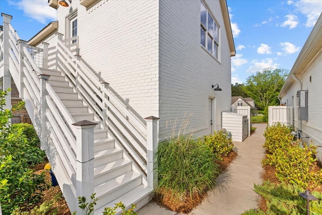 view of property exterior with brick siding and stairs