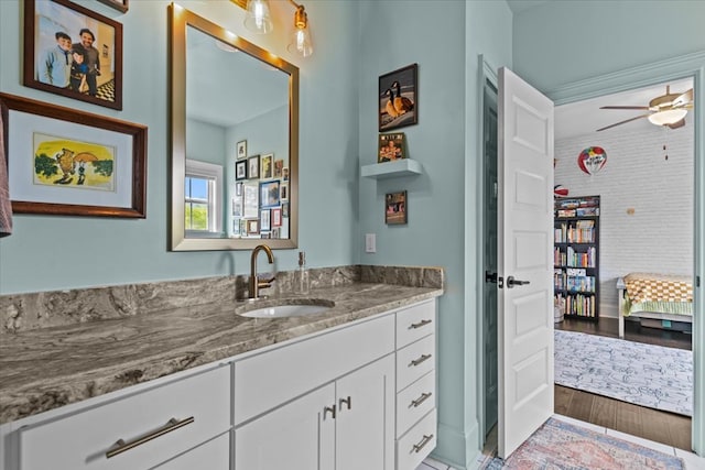 bathroom with wood finished floors, ceiling fan, connected bathroom, and vanity