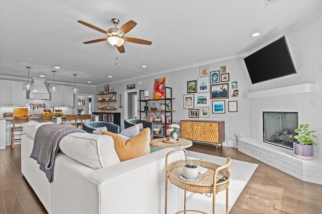 living area with recessed lighting, ornamental molding, and a ceiling fan