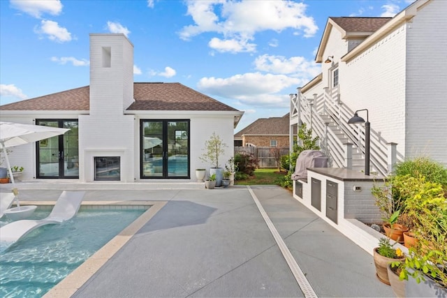 back of house featuring a fenced in pool, a shingled roof, a patio area, and fence