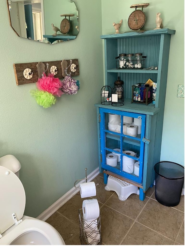 bathroom with tile patterned floors, toilet, and baseboards