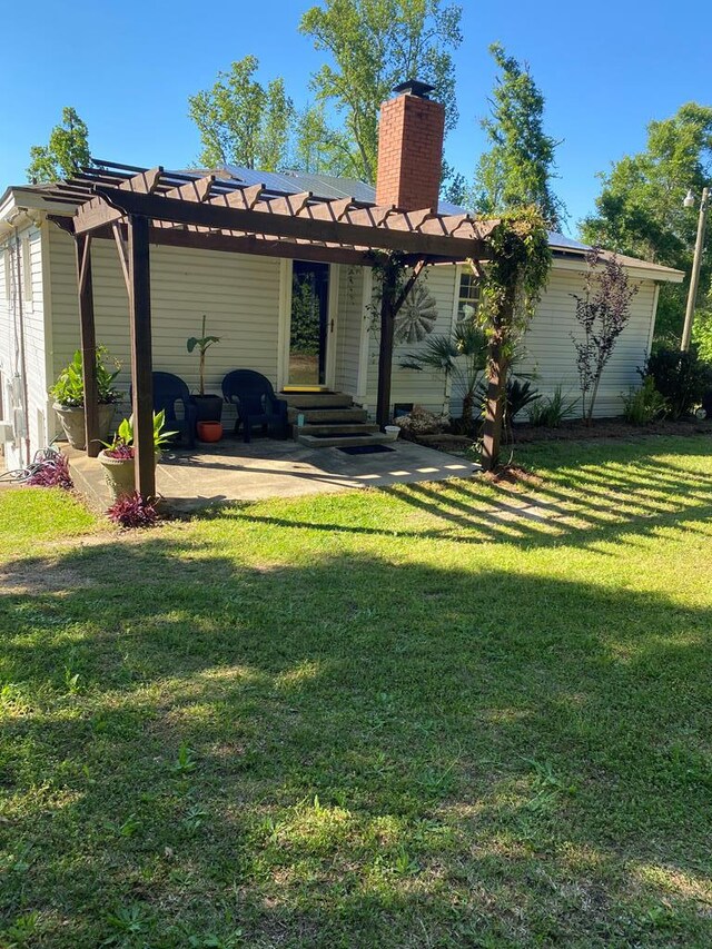 back of house with a patio, a lawn, a chimney, and a pergola