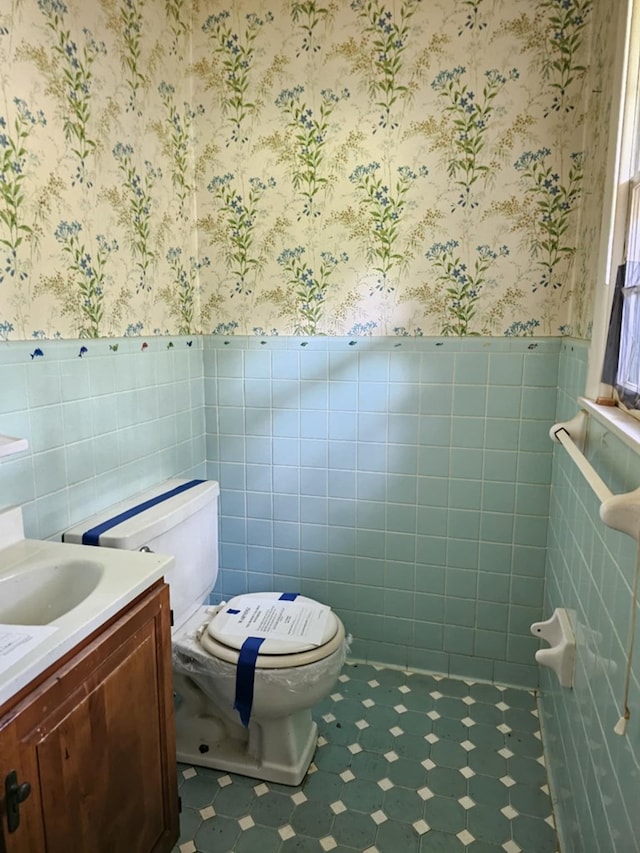 228 Sharon Ln, Ozark, AL 36360 - half bath with wallpapered walls, wainscoting, vanity, tile patterned floors, and tile walls