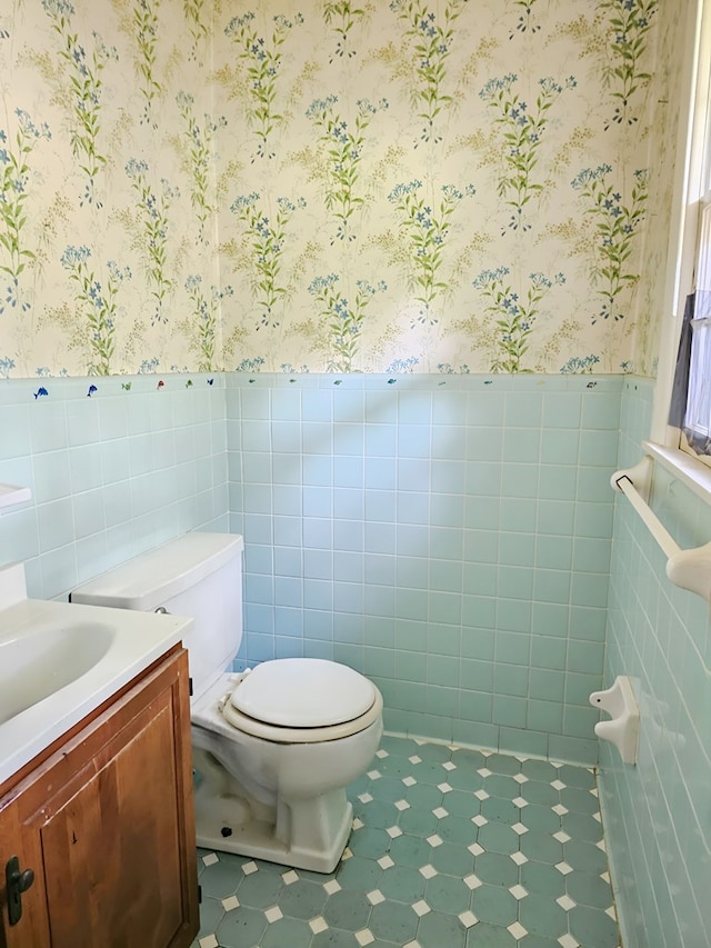 228 Sharon Ln, Ozark, AL 36360 - half bathroom featuring wallpapered walls, wainscoting, vanity, tile walls, and tile patterned floors