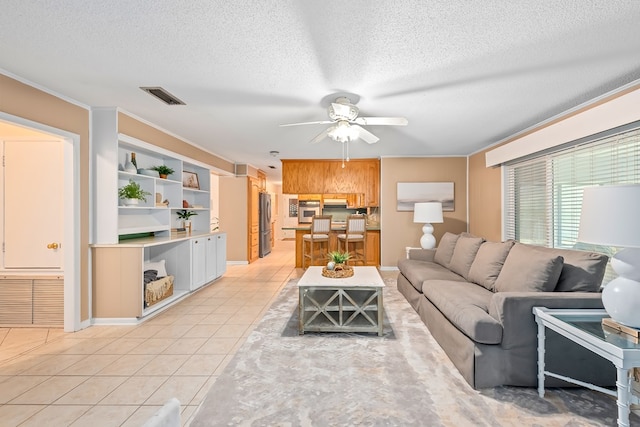 living room featuring a textured ceiling, ceiling fan, and light tile patterned floors