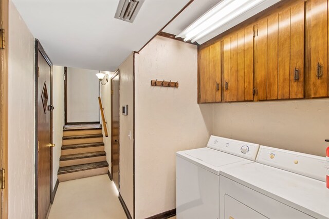 clothes washing area featuring cabinets and independent washer and dryer