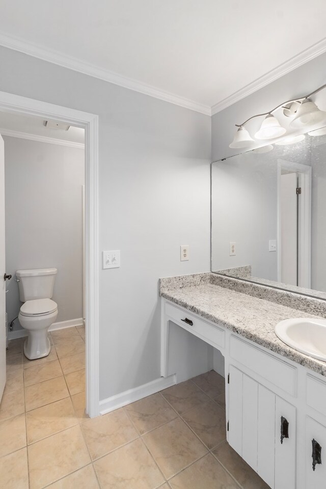 bathroom with toilet, vanity, tile patterned floors, and ornamental molding