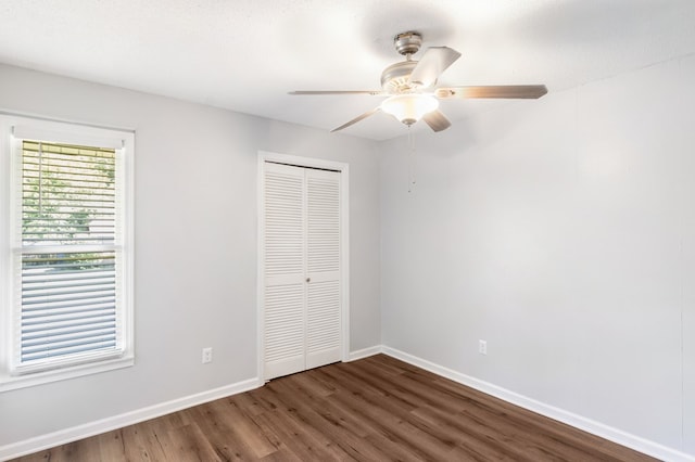 unfurnished bedroom with a closet, ceiling fan, dark hardwood / wood-style flooring, and a textured ceiling