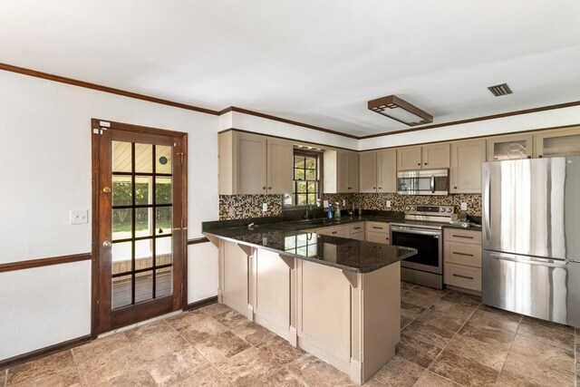 kitchen featuring kitchen peninsula, appliances with stainless steel finishes, tasteful backsplash, dark stone countertops, and a breakfast bar area