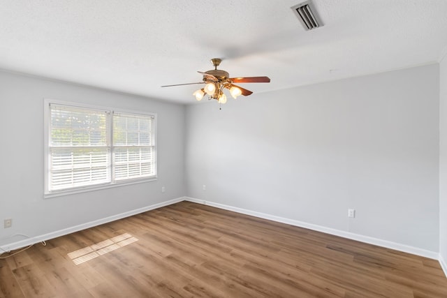 spare room with hardwood / wood-style flooring, ceiling fan, and a textured ceiling